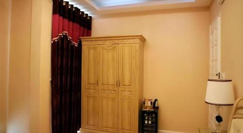 a large wooden cabinet in the corner of a room at Hanoi Milan Hotel in Hanoi