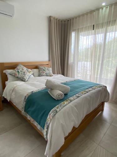 a bedroom with a bed with a large window at Villa Paradisiaque au cœur de Grand Baie in Mauritius