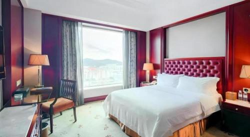 a bedroom with a large bed and a large window at King Century Hotel in Zhongshan