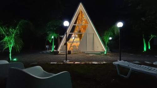 a small house with a triangular roof at night at White DIAMOND in Chalkidiki in Vergia