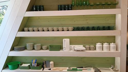 a shelf with cups and other items on it at White DIAMOND in Chalkidiki in Vergia