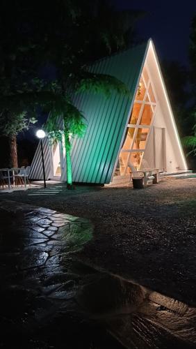 a large building with a green roof at night at White DIAMOND in Chalkidiki in Vergia