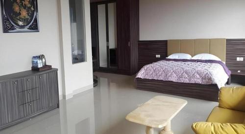 a bedroom with a bed and a couch and a chair at Fafa Hill Hotel and Resort in Bogor