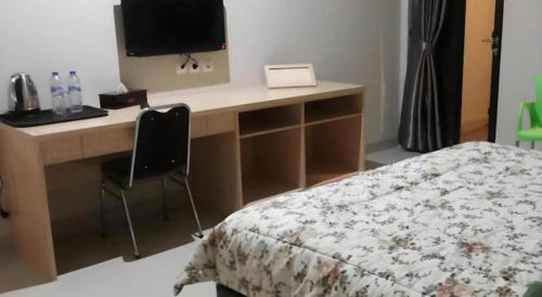 a bedroom with a desk with a bed and a computer at Fafa Hill Hotel and Resort in Bogor