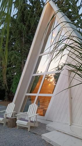 two white chairs sitting in front of a large window at White DIAMOND in Chalkidiki in Vergia
