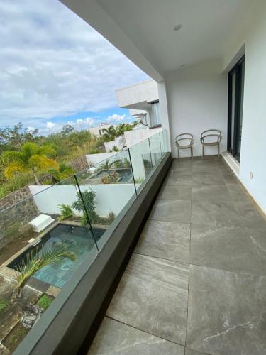 a balcony with chairs and a view of the ocean at Villa Paradisiaque au cœur de Grand Baie in Mauritius
