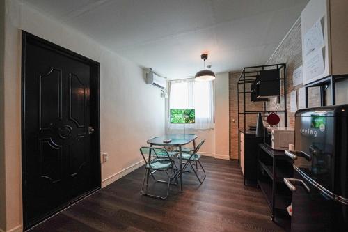 a dining room with a table and a black door at 광안해변家 #Gwangan Beach House in Busan