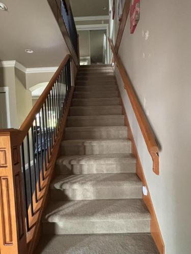 a staircase in a home with wooden railings at Rosehouse 2Bedrooms sleep 4 2nd floor private bathroom in Coquitlam