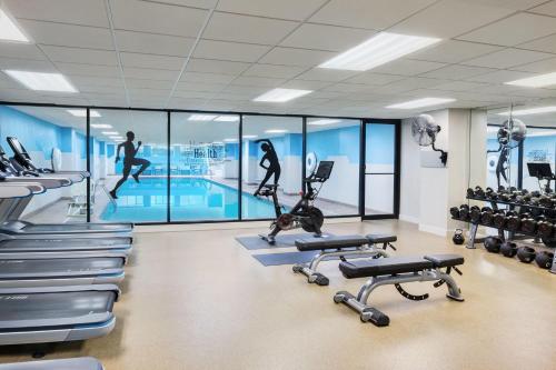 a gym with a swimming pool and exercise equipment at Hyatt Regency Schaumburg Chicago in Schaumburg