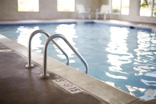 a swimming pool with a stairway leading to the water at Hyatt House Fishkill-Poughkeepsie in Fishkill