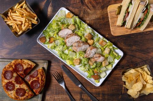 a table with a plate of salad and a plate of pizza at Hyatt Place Atlanta / Alpharetta / Windward Parkway in Alpharetta