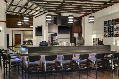 a bar in a room with a bunch of chairs at Hyatt Place Atlanta / Norcross / Peachtree in Norcross