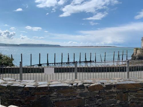 a fence in front of a body of water at Driftwood in Aberdyfi