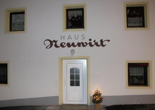 a sign on the wall of a building with a door at Haus Neuwirt in Sautens