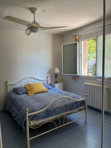 une chambre avec un lit et un ventilateur de plafond dans l'établissement Villa La Hume proche port plage commodités Bassin d'Arcachon avec piscine chauffée, à Gujan-Mestras