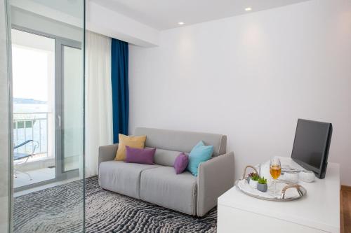a living room with a couch and a tv at Hotel Casa del Mare - Blanche in Herceg-Novi