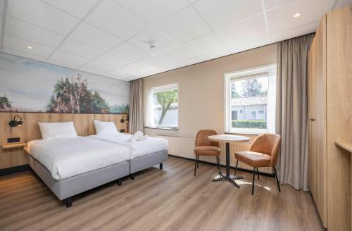 a hotel room with a bed and a table and chairs at Fletcher Hotel-Restaurant Het Witte Huis in Amersfoort