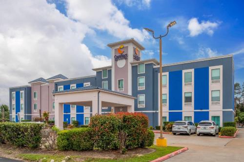 a blue and white building with cars parked in a parking lot at Comfort Inn & Suites Houston FM1960 - Champions in Houston