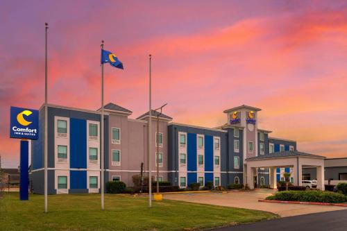 a building with a flag in front of it at Comfort Inn & Suites Houston FM1960 - Champions in Houston