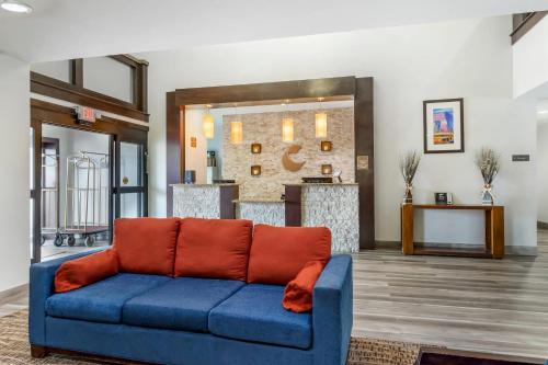 a living room with a blue couch with orange pillows at Comfort Inn & Suites Houston FM1960 - Champions in Houston