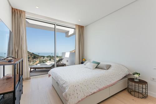 a bedroom with a bed and a large window at Palo Alto in Marbella