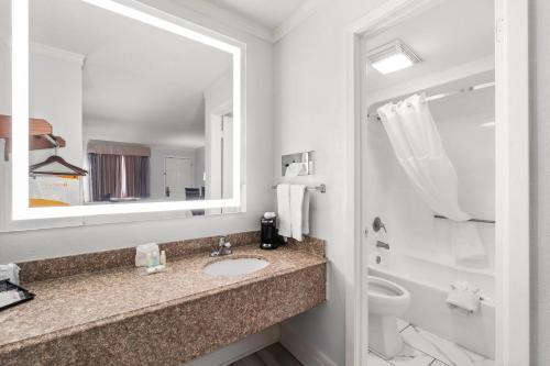 a bathroom with a sink and a toilet and a mirror at Quality Inn Forrest City I-40 in Forrest City