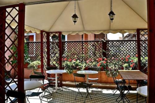 d'une terrasse avec des tables, des chaises et des fleurs. dans l'établissement Hotel San Gallo, à Venise