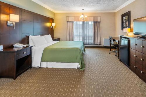 a hotel room with a bed and a flat screen tv at Rodeway Inn Festival in Stratford