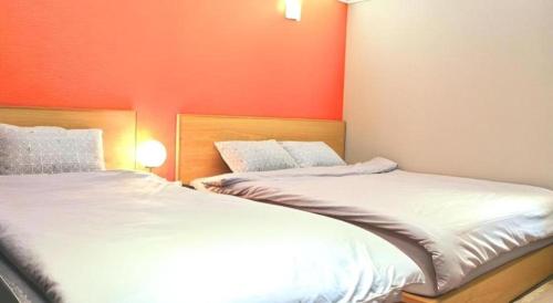 two beds sitting next to each other in a room at Jeju Sejong Hotel in Jeju