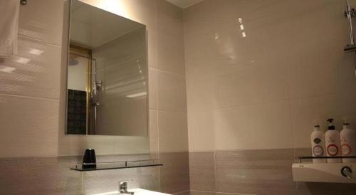 a bathroom with a sink and a mirror at Jeju Sejong Hotel in Jeju
