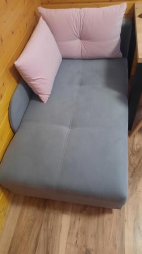 a blue bed with two pillows on a wooden floor at Penzion a drevenica pri Hati in Terchová