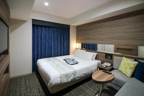 a hotel room with a bed and a couch at Almont Hotel Naha Kenchomae in Naha