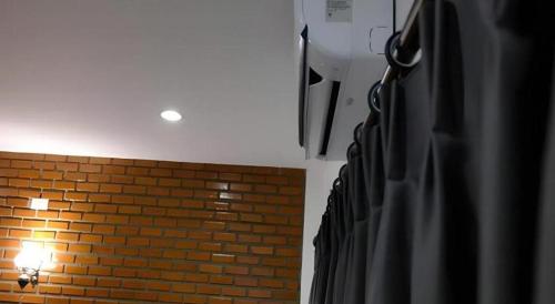 a room with a brick wall and a light at The Connect Chiang Mai in Chiang Mai
