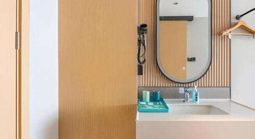 a bathroom with a sink and a mirror at City Comfort Inn Wuhan Hankou Railway Station West Square in Wuhan