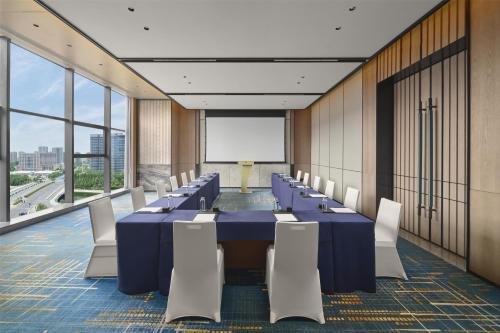 a conference room with a long table and chairs at Doubletree By Hilton Zhengzhou East in Zhengzhou