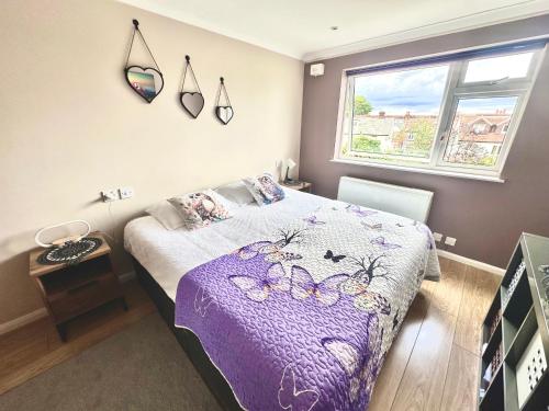 a bedroom with a bed with a purple blanket at Heart of Windsor in Windsor