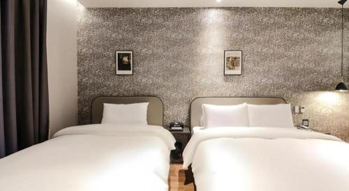 two beds sitting next to each other in a room at Gimhae Perfect Hotel in Gimhae