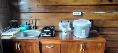 a kitchen counter with a sink and a coffee maker at The Aisyah Cabin in Wonosobo