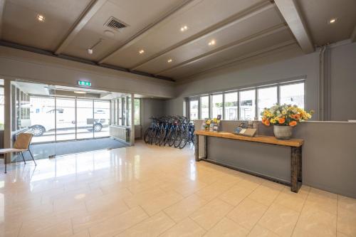 a lobby with a desk with flowers on it at Fletcher Hotel-Restaurant Het Witte Huis in Amersfoort