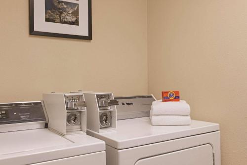 a laundry room with three washing machines and towels at Country Inn & Suites by Radisson, Madison, WI in Madison