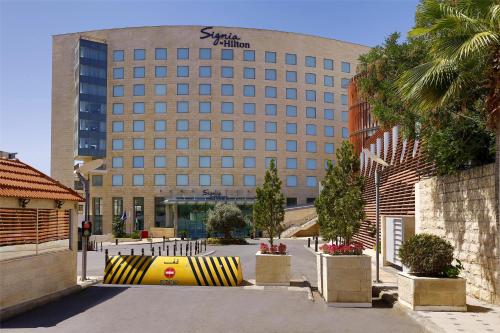 a building with a large yellow and black object in front of it at Signia by Hilton in Amman