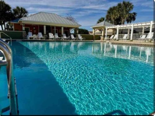 una gran piscina de agua azul frente a una casa en Cozy 2BR in The Villages With BBQ and 4 Seaters Golfcart King Bed, en Wildwood