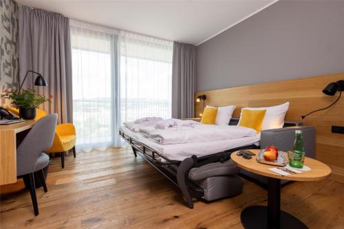 a hotel room with a bed and a table at Best Western Parkhotel Hagenberg in Hagenberg im Mühlkreis