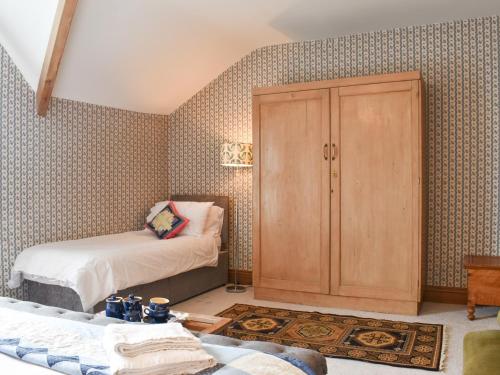 a bedroom with a cupboard and a bed at Hillside House in Kirkby Lonsdale
