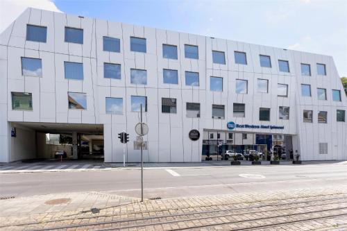 a large white building with a street in front of it at Best Western Hotel Spinnerei Linz in Linz