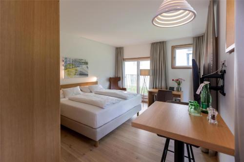 a bedroom with a bed and a desk and a table at Best Western Hotel Spinnerei Linz in Linz