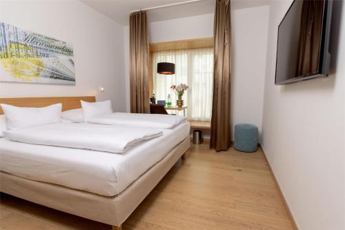 a hotel room with two beds and a television at Best Western Hotel Spinnerei Linz in Linz
