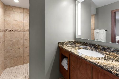 a bathroom with a sink and a shower at Baymont by Wyndham Jamestown Conference Center & Water Park in Jamestown