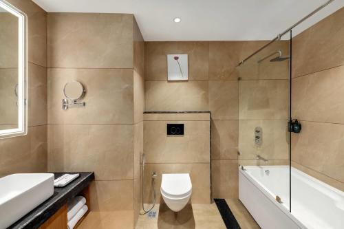 a bathroom with a toilet and a shower and a sink at Ramada Encore by Wyndham Viramgam in Viramgām