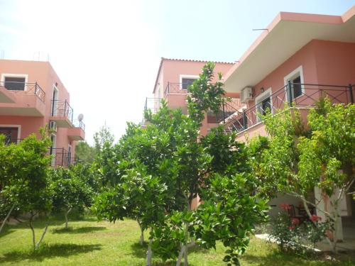 an apartment building with trees in front of it at Ekaterini Apartments in Gouvia
